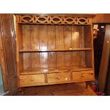 A pine hanging plate rack with three short drawers