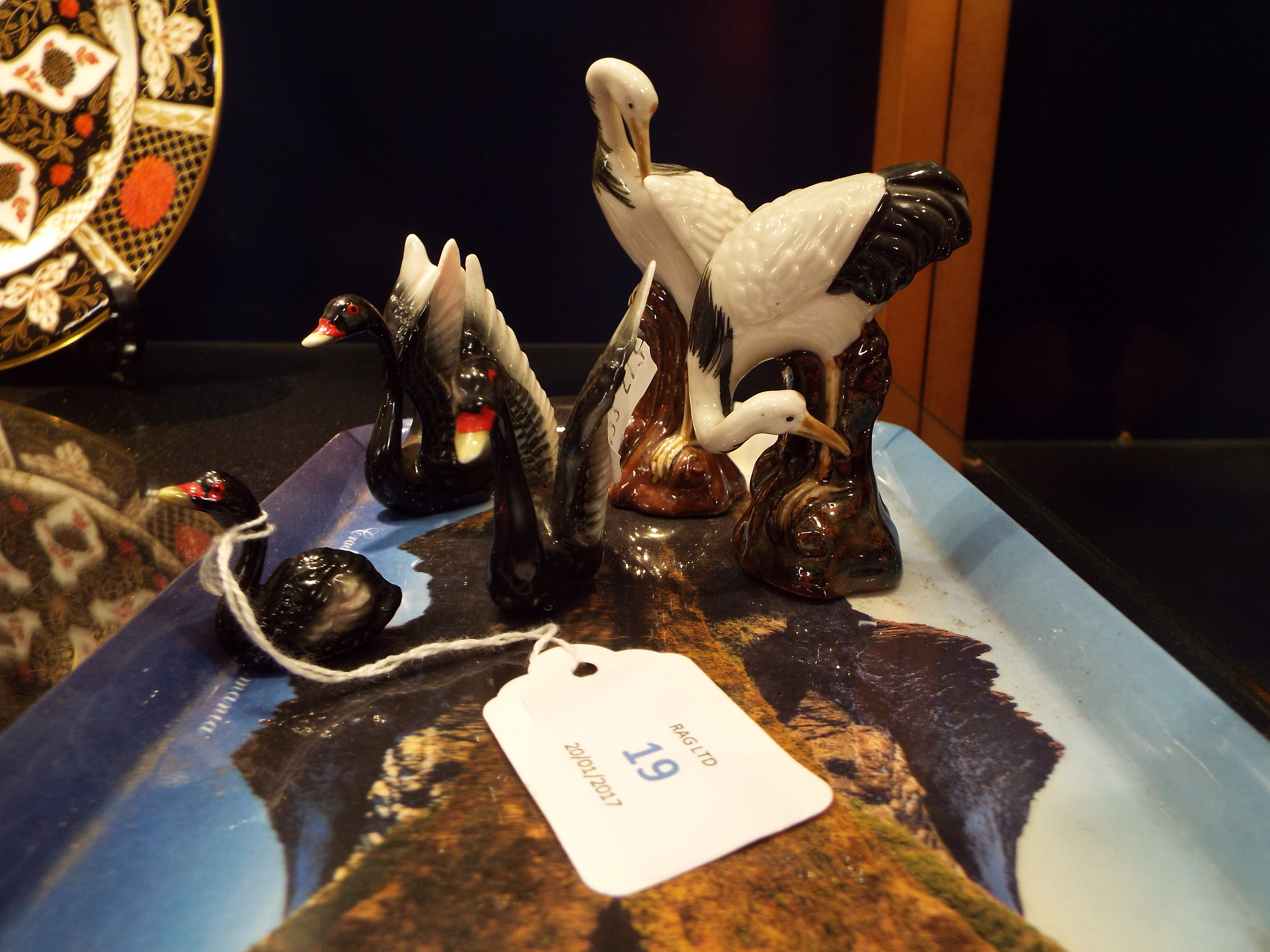 A set of three unmarked black swan figurines and two Chinese crane figurines