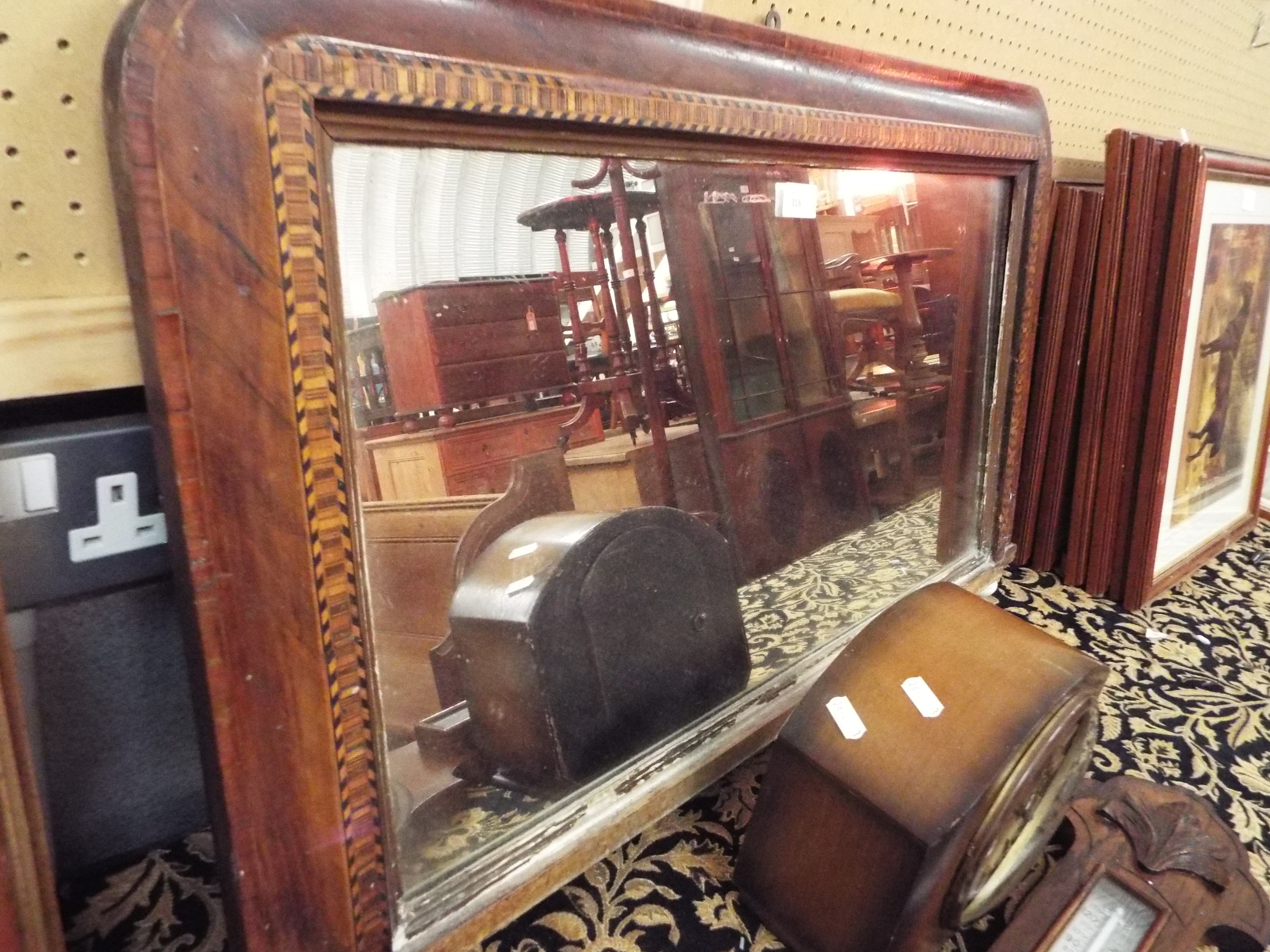 A Victorian cross banded and chequered strung over mantle mirror with ceramic bun feet