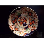 A Chinese scalloped edge charger hand painted in the Imari style pattern with flowers and