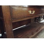 An early 20thC oak three tier buffet fitted with central drawer and raised on square supports and