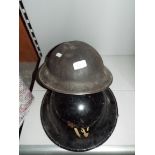 An air raid warden's tin helmet together with another similar