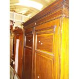 An Edwardian lined inlaid two door wardrobe raised on bracket feet