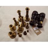 A pair of War Office issue binoculars and a selection of miniature brass candlesticks