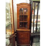 A burr walnut glazed corner cabinet with cupboard below