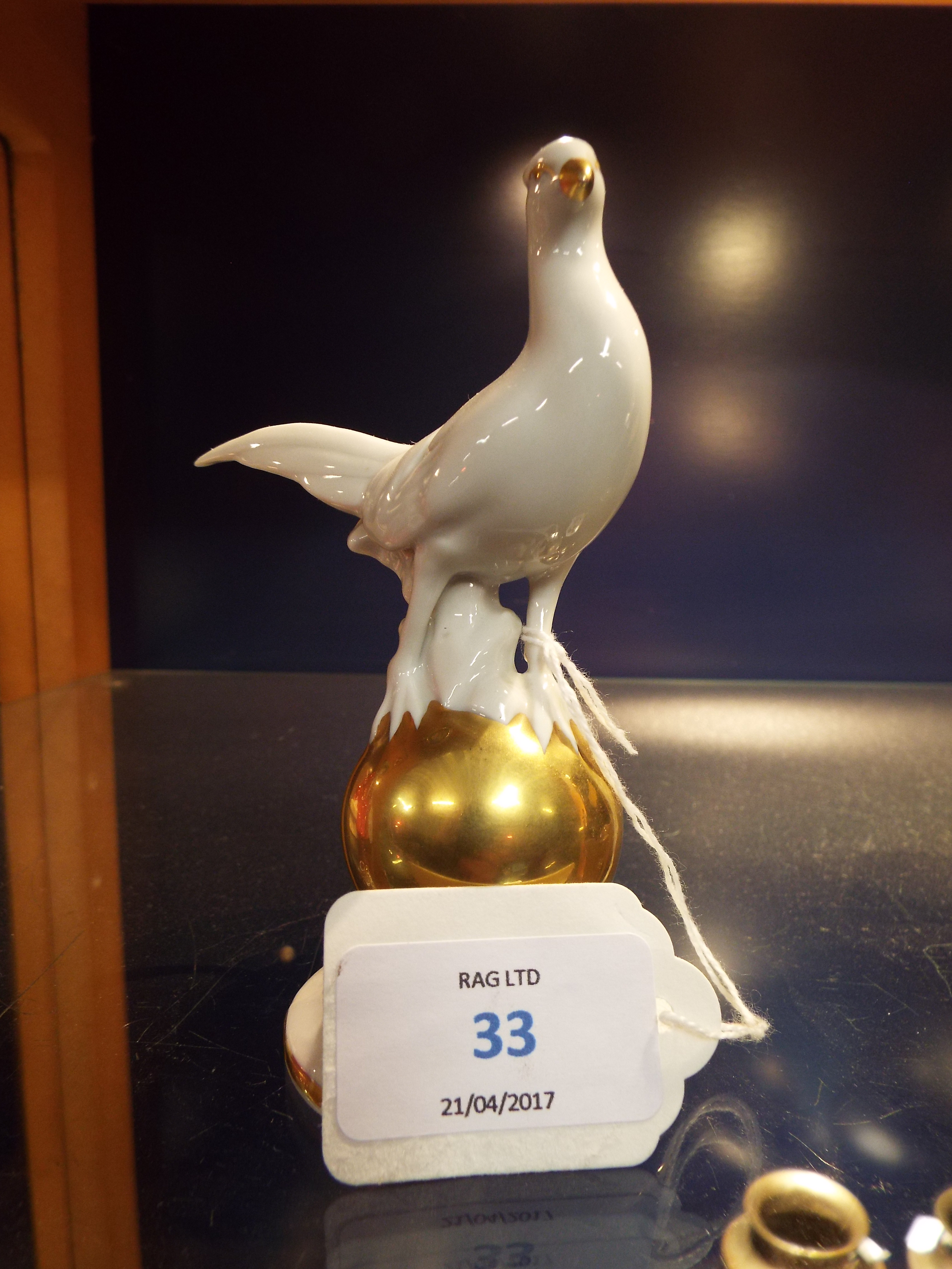 A Gerold Porzellan Bavarian porcelain figurine of a 'Pheasant' resting on a gold globe