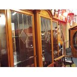 A 20thC Italian lacquered break-front triple display cabinet with brass lit doors each enclosing