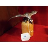 An early 20thC chrome car mascot in the form of an eagle mounted on a wooden stand