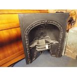 A black painted cast iron fire place with embossed floral decoration built in fire grate