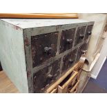 A shabby chic green painted chest of seven small drawers