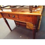 A teak hall table having central frieze drawer resting on turned supports