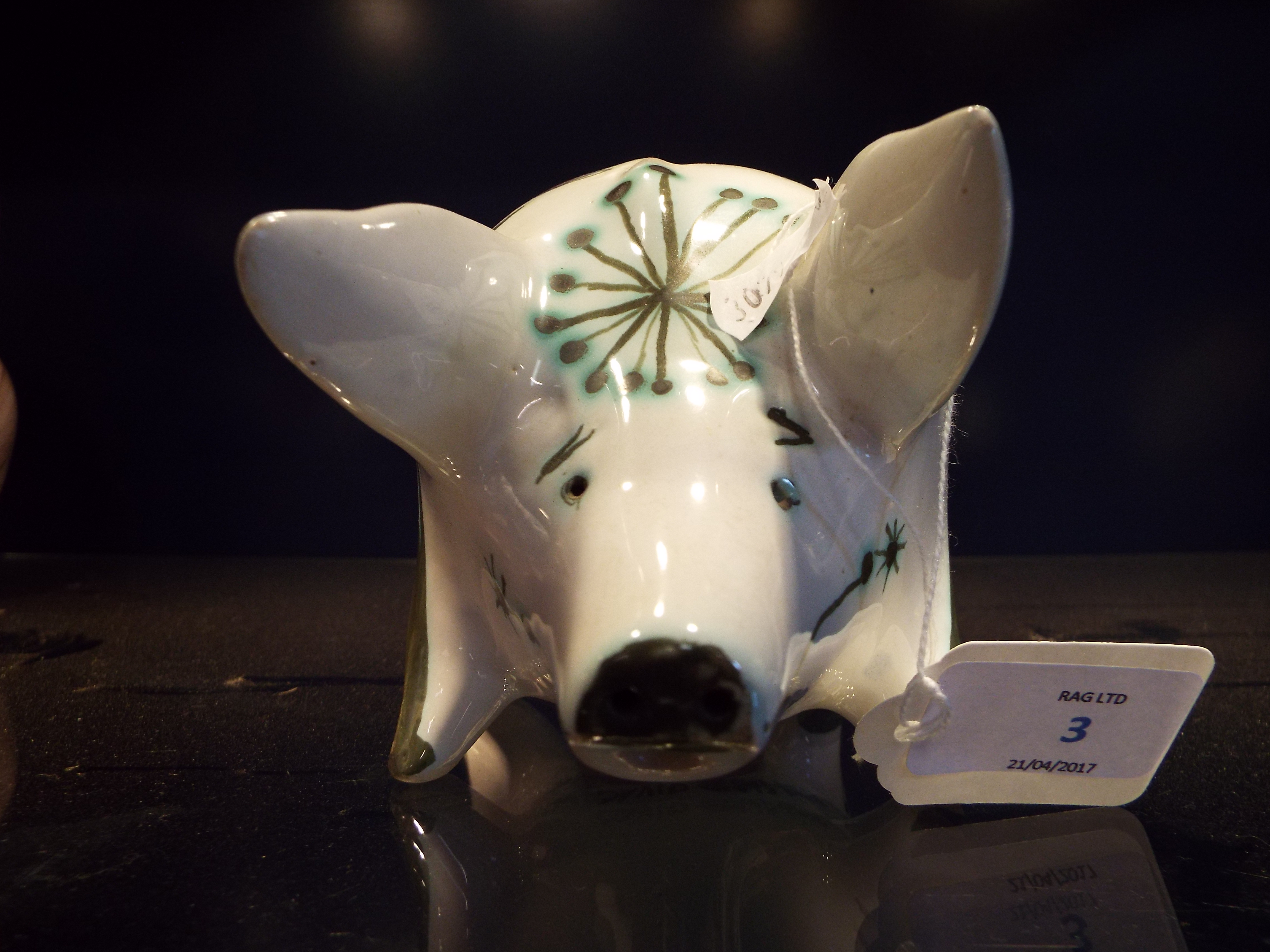A David Sharp Rye Pottery white glazed money box in the form of a pig with blue floral decoration