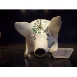 A David Sharp Rye Pottery white glazed money box in the form of a pig with blue floral decoration