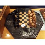 An African ebony and hard-wood carved chess set, the pieces in the form of figures,