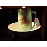 An Art Deco mottled green wash basin and jug decorated with a cottage scene