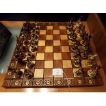 A 20thC chess set with lead hand-painted Crimean War military figure pieces an hand carved folding