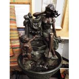 A reproduction resin bronze patinated water feature depicting a classical female with putti,