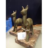 A pair of bronzed bookends in the form of fawns resting on a marble plinth