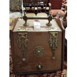 An oak coal box with ornate brass fittings and handle with shovel