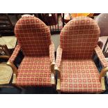 A pair of good quality oak framed arched back elbow chairs upholstered win a red ground floral