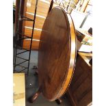 A Victorian mahogany circular snap-top breakfast table resting on four carved supports