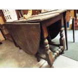 An 18thC oval oak gate leg table raised baluster and cup and cover turned supports