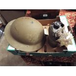 A WWI British tin helmet together with a military water bottle and cover,