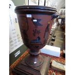 An early 20thC terracotta twin handled urn hand-painted with Egyptian deities,