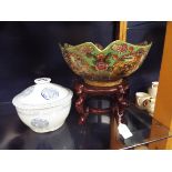 A large Satsuma style famille verte bowl decorated with geisha and bonsai resting on a hardwood