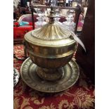 A heavy gilt brass urn and cover of gadrooned fluted form with ornate drop ring handle and stand