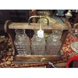 A late Victorian mahogany tantalus with brass fitting complete with three decanters
