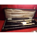 A Victorian cased carving set with ivory handles and silver finials decorated with bulls and laurel