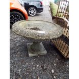 A large circular reconstituted stone garden urn with egg and dart decoration