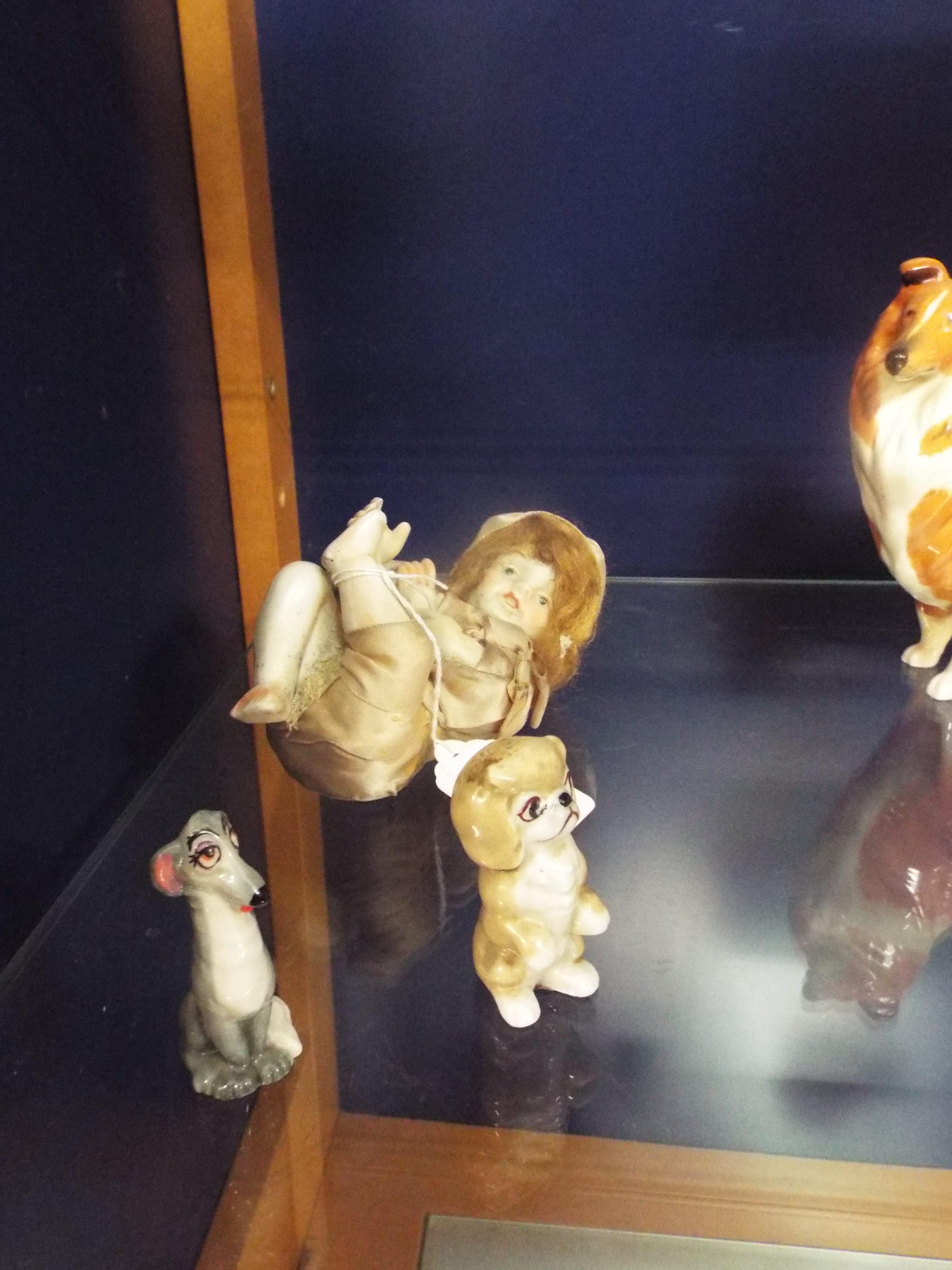 A 19thC porcelain piano baby together with two Wade Disney figures from 'Lady and the Tramp'