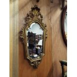 A gilt gesso shield-shaped bevelled glass mirror