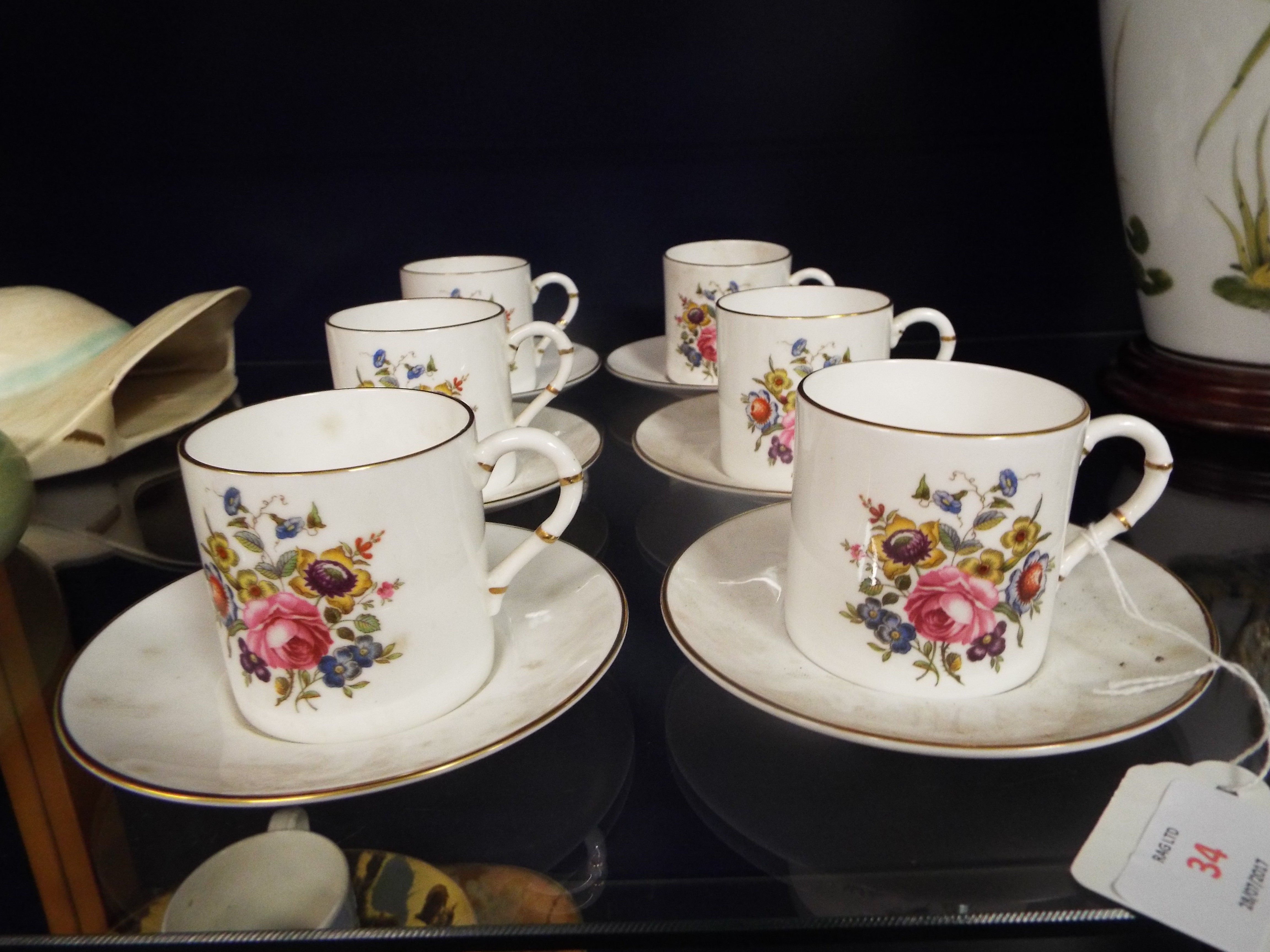 Six Royal Worcester coffee cans and saucers with faux bamboo handles and decorated with floral