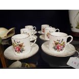 Six Royal Worcester coffee cans and saucers with faux bamboo handles and decorated with floral