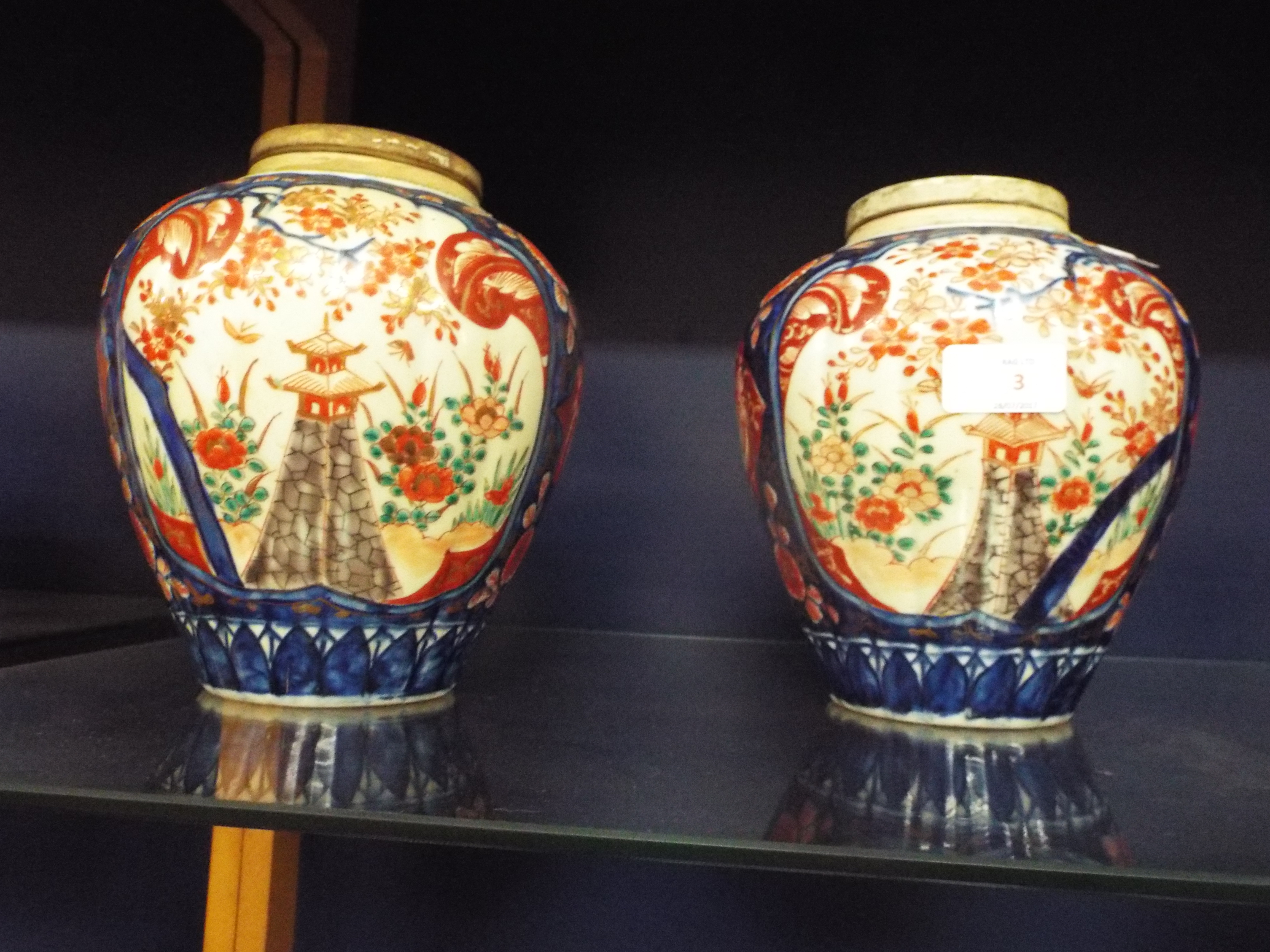 A pair of Oriental lidded ginger jars having mainly blue and red decoration,