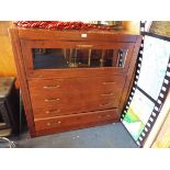 A pine effect gentleman's chest fitted with one glazed over four long drawers