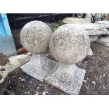 A pair of reconstituted stone orb shaped finials