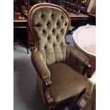 A Victorian walnut framed spoon and button back armchair with scrolling arm and serpentine seat