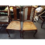 A pair of walnut side chairs with cane seats