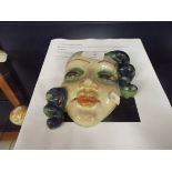A 1930s Goldscheider wall mask depicting a beautiful female face,