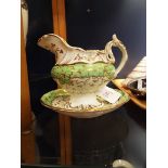 A Rockingham style cream jug and stand decorated with gilt vines and leaves with green and white