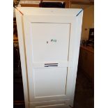 A white painted single wardrobe with drawer below