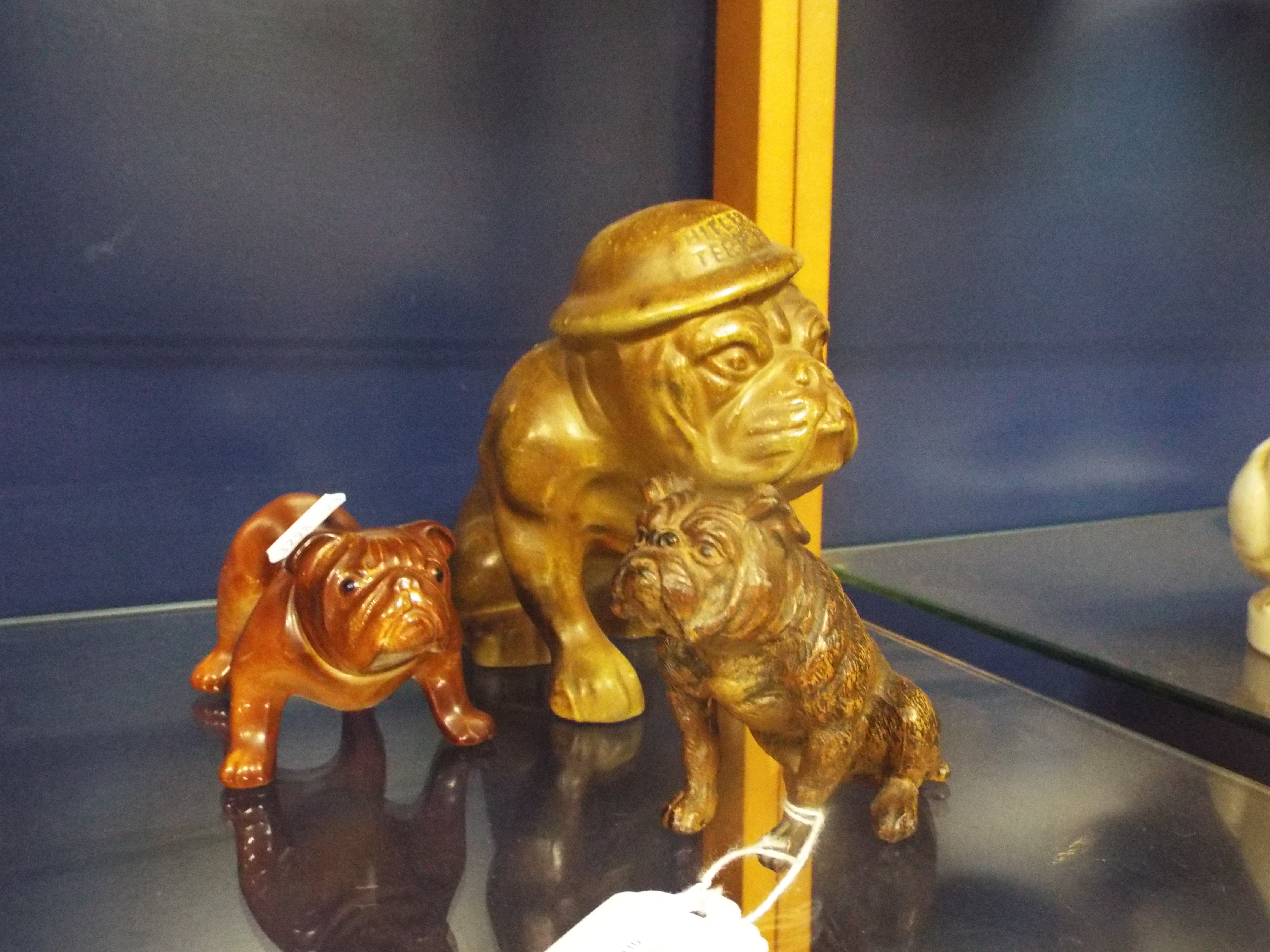 A WWII ceramic figure of a bulldog with helmet inscribed 'Hitler's Terror' together with an