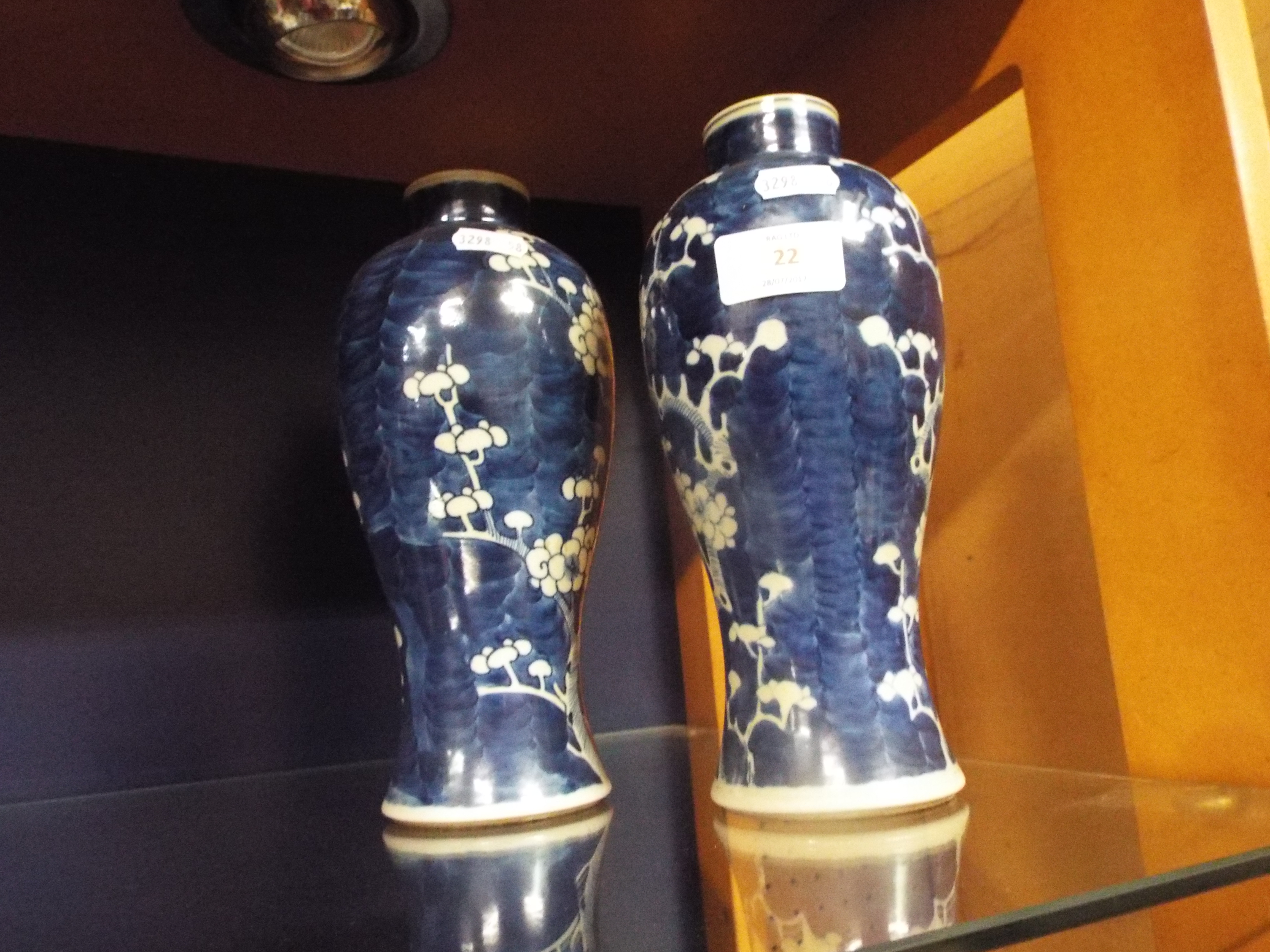 A pair of blue and white baluster shaped vases decorated with prunus,