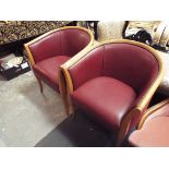 A pair of burgundy faux leather beech framed tub chairs