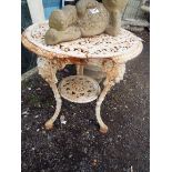 An early 20thC white painted floral decorated cast iron two tier garden table with female mask