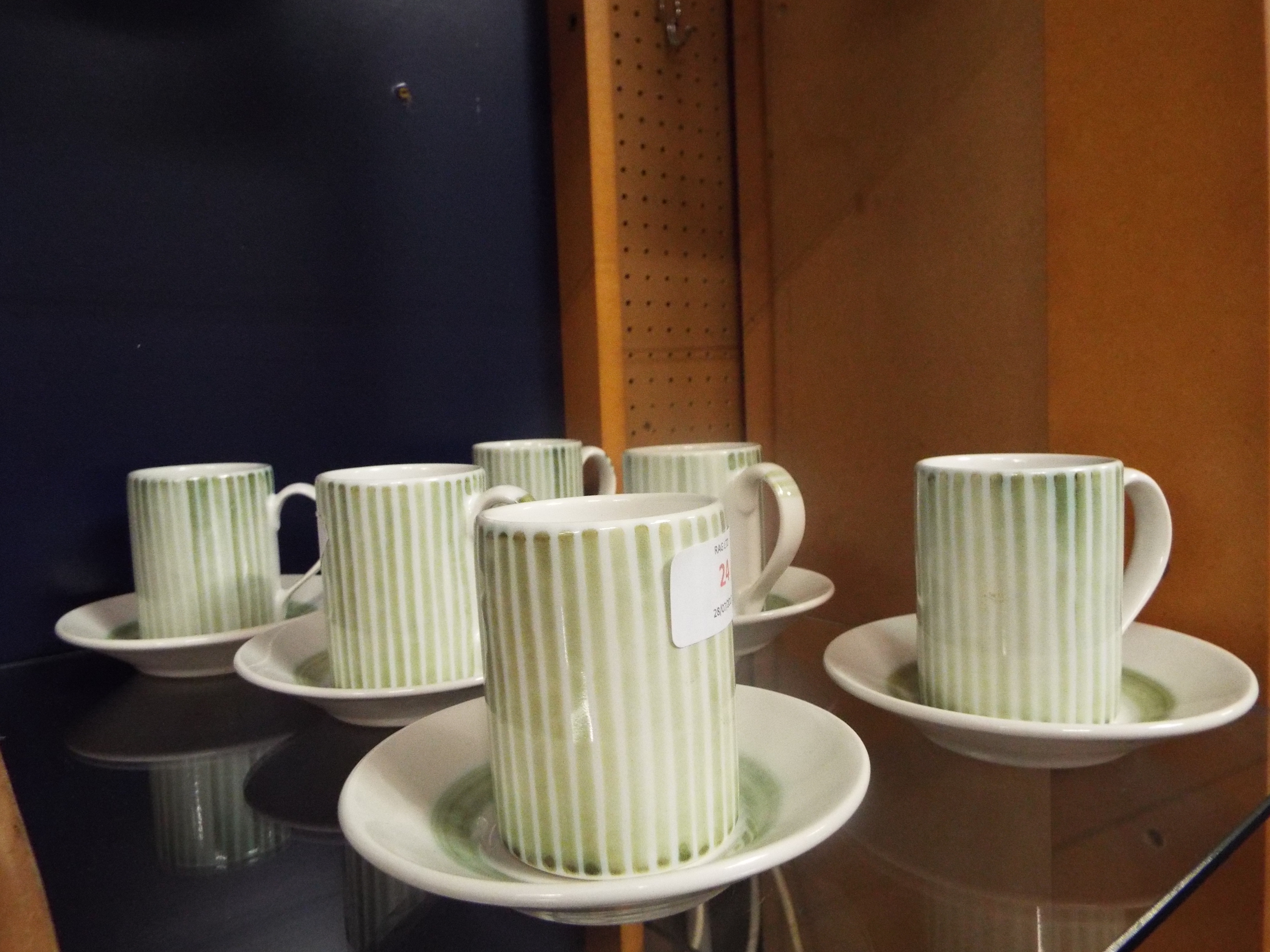 A set of six Rye Pottery coffee cans and saucers with green stripe pattern